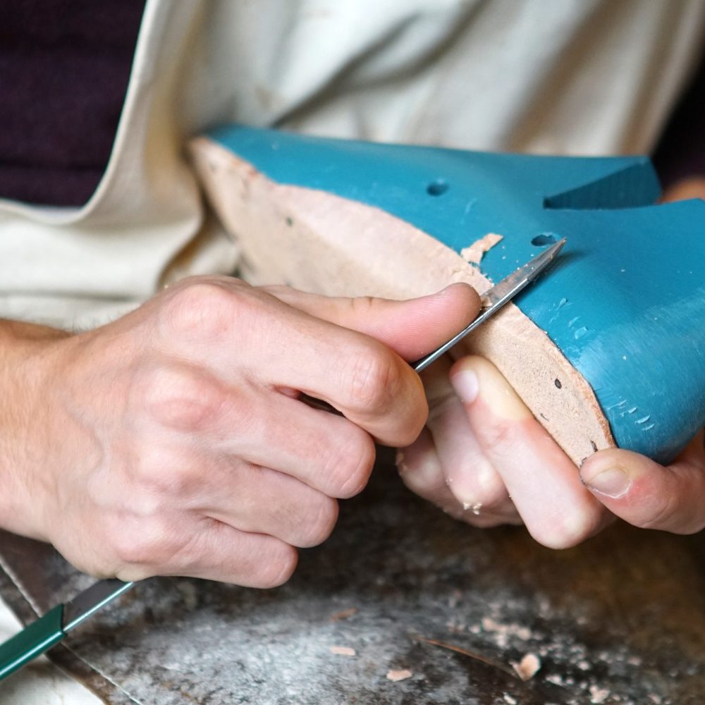 A goldsmith at the bench, the work held over the bench pin.