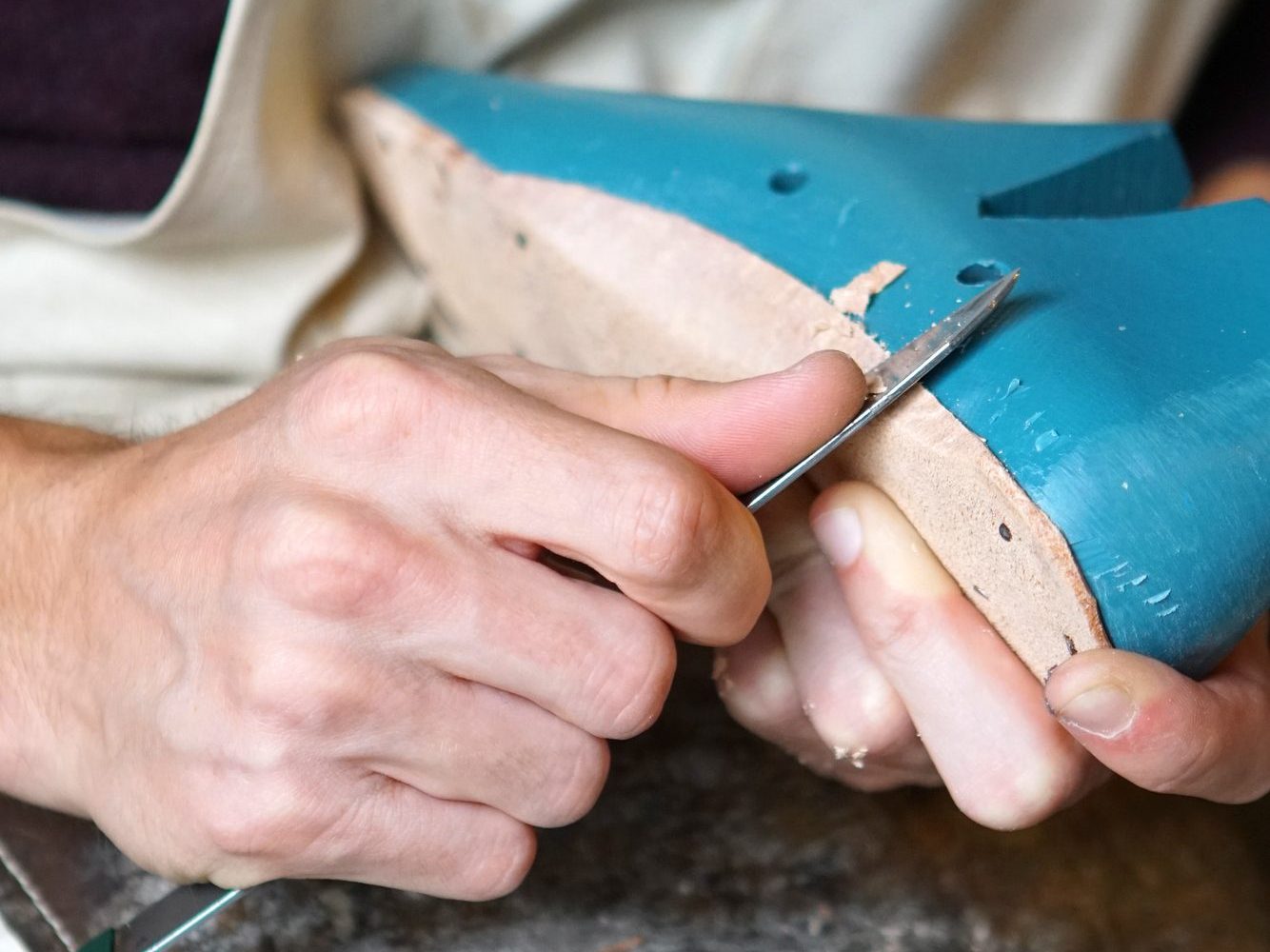 A goldsmith at the bench, the work held over the bench pin.