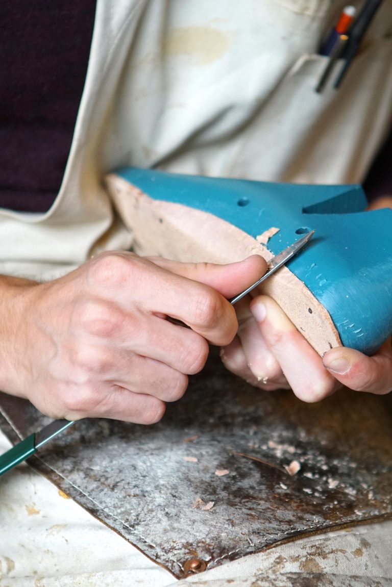 A goldsmith at the bench, the work held over the bench pin.