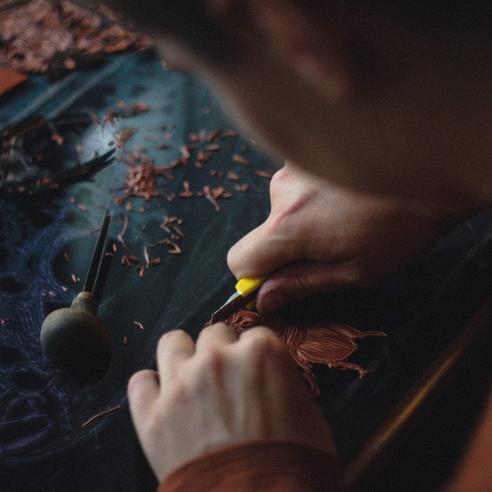 A goldsmith at the bench, the work held over the bench pin.