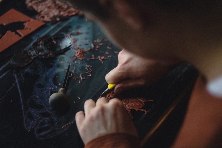 A goldsmith at the bench, the work held over the bench pin.