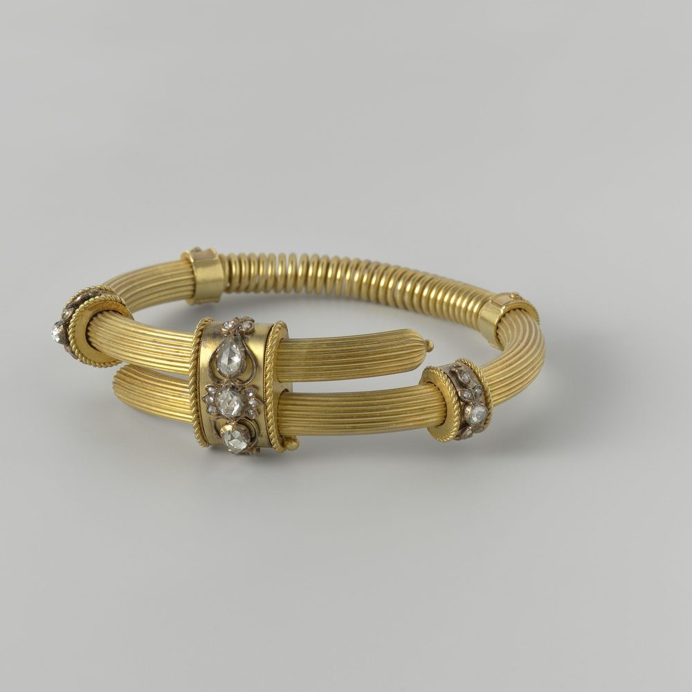 A bracelet coiled loosely so the clasp and the line of links are both visible.