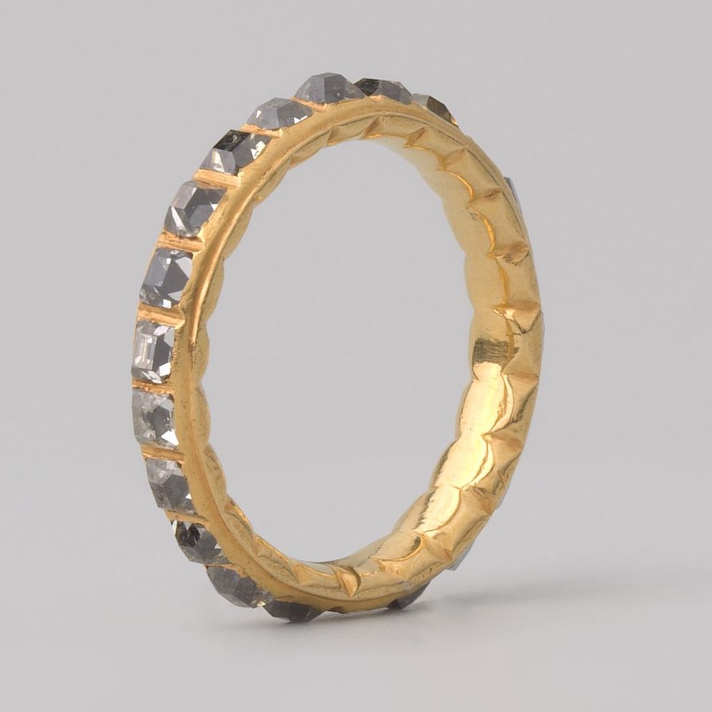 A band set continuously with small stones around its whole circumference.
