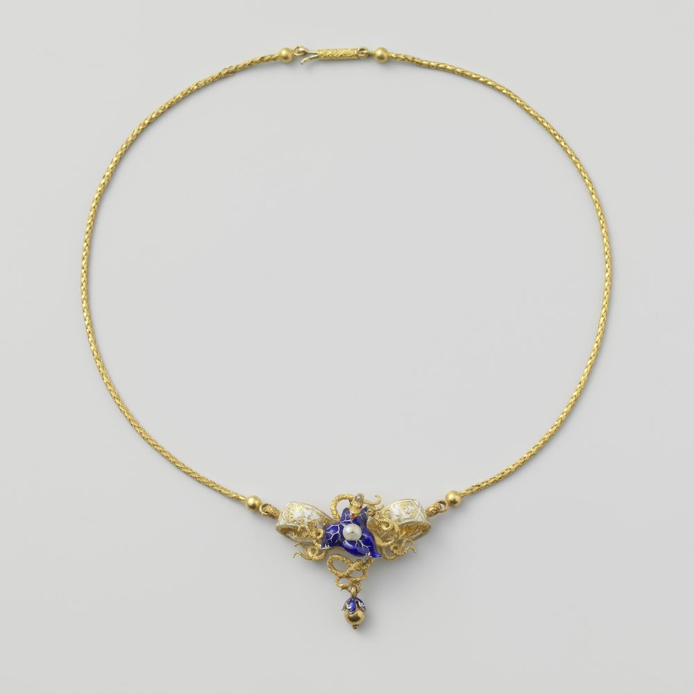 A fine chain laid in a loose curve with its pendant resting at the lowest point.